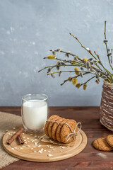 Wall Mural - homemade oatmeal cookies on a wooden tray with burlap in a rustic style. Spring composition with a basket with a willow. The concept of a home bakery, proper and healthy nutrition. Copy space for text