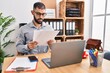 © Krakenimages.com - Young hispanic man business worker using laptop reading document at office
