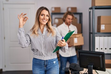 Poster - Blonde woman working at small business ecommerce doing ok sign with fingers, smiling friendly gesturing excellent symbol