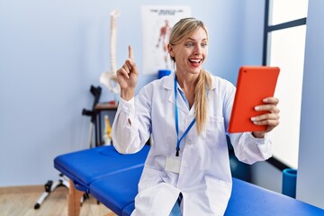 Poster - Beautiful woman working at pain recovery clinic doing video call smiling with an idea or question pointing finger with happy face, number one