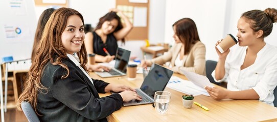 Group of young businesswomen smiling happy working at the office.