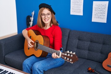 Poster - Young redhead woman musician smiling confident playing classical guitar at music studio