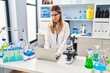 © Krakenimages.com - Young blonde woman wearing scientist uniform using laptop at laboratory