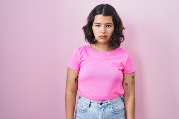 Sticker - Young hispanic woman standing over pink background skeptic and nervous, frowning upset because of problem. negative person.