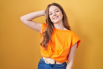 Sticker - Caucasian woman standing over yellow background smiling confident touching hair with hand up gesture, posing attractive and fashionable