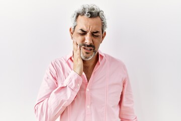 Poster - Middle age hispanic man standing over isolated background touching mouth with hand with painful expression because of toothache or dental illness on teeth. dentist