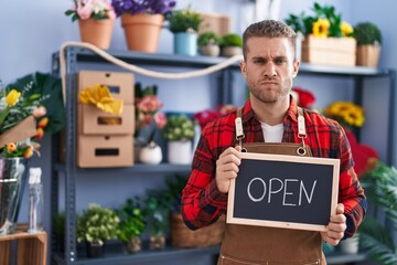 Sticker - Young caucasian man working at florist holding open sign skeptic and nervous, frowning upset because of problem. negative person.