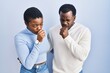 Young african american couple standing over blue background feeling unwell and coughing as symptom for cold or bronchitis. health care concept.