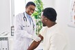 © Krakenimages.com - Man and woman doctor and patient putting band aid at clinic