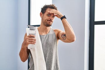 Canvas Print - Young hispanic man wearing sportswear drinking water worried and stressed about a problem with hand on forehead, nervous and anxious for crisis