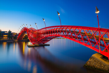 Wall Mural - A bridge in the city at night. The bridge on the blue sky background during the blue hour. Architecture and design. The Python Bridge, Amsterdam, the Netherlands.