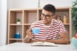 © Krakenimages.com - African american man reading book drinking coffee at home