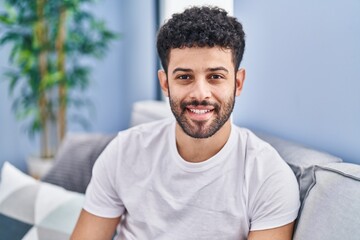 Canvas Print - Young arab man smiling confident sitting on sofa at home