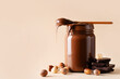 © Denira - Chocolate paste in jar with nuts on cut wooden board