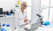 © Krakenimages.com - Middle age blonde woman wearing scientist uniform writing on clipboard working at laboratory