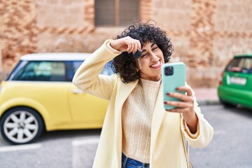 Sticker - Young middle east woman excutive holding key of new car making selfie by smartphone at street