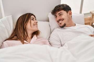 Poster - Mand and woman couple smiling confident lying on bed at bedroom