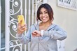 © Krakenimages.com - Young hispanic woman wearing sportswear looking stopwatch using smartphone at street