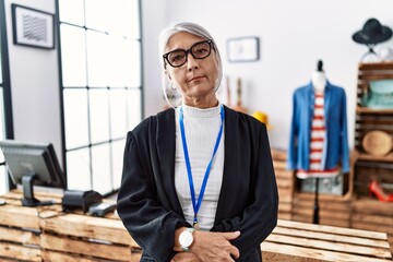 Sticker - Middle age grey-haired woman working as manager at retail boutique relaxed with serious expression on face. simple and natural looking at the camera.