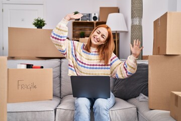 Wall Mural - Young caucasian woman smiling confident using laptop at new home