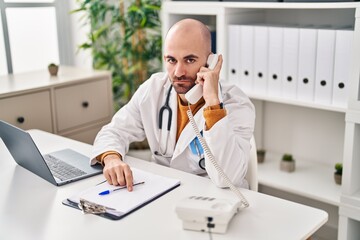 Poster - Young bald man with beard working on telephone appointment thinking attitude and sober expression looking self confident