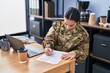 © Krakenimages.com - Young hispanic woman army soldier using laptop writing on document at office