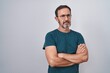 © Krakenimages.com - Middle age man standing with serious expression and arms crossed gesture over isolated white background