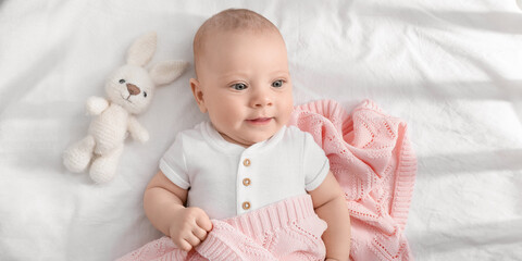 Wall Mural - Portrait of cute little baby lying on bed, top view