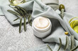 © Pixel-Shot - Jar of cream with plant branches and towel on grunge background, closeup