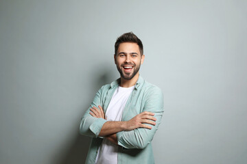 Poster - Young man laughing on light grey background. Funny joke