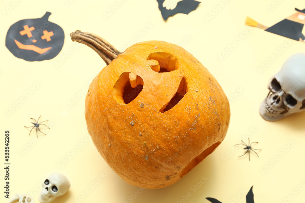 Jack-O-Lantern pumpkin with Halloween decor on beige background