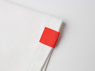 blank red color clothing label on white t shirt sleeve