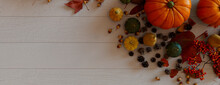 Thanksgiving Background With Autumn Leaves, Pumpkins And Pine Cones On A White Wood Surface.