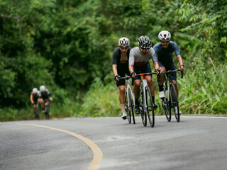 Groups of cyclists riding road bikes in the morning are climbing.