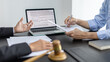© Puwasit Inyavileart - Lawyer or judge has recommend a client sign a legal agreement in the courtroom, Legal Agreement Documents and Business Litigation Forms, scales of justice, law hammer, Litigation and legal services.