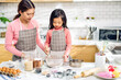 © Art_Photo - Portrait of enjoy happy love asian family mother and little toddler asian girl daughter child having fun cooking together with dough for homemade bake cookie and cake ingredient on table in kitchen