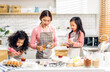 © Art_Photo - Portrait of enjoy happy love asian family mother and little toddler asian girl daughter child having fun cooking together with dough for homemade bake cookie and cake ingredient on table in kitchen