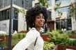 © fotofabrika - Portrait of young african woman with afro hairstyle smiling in urban background