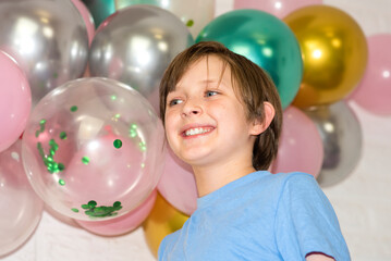 Wall Mural - portrait of a happy smiling boy on a holiday in front of the Balloons