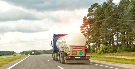 A truck with a semi-trailer tank transports a dangerous cargo of liquefied gas. The concept of transportation of flammable goods. Copy space for text, industry