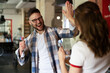 © JustLife - Cheerful coworkers giving high five. Businessman and businesswoman in office