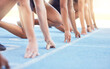 Runners with hands on start line on the track for a race, ready to run. Racing challenge or sprint at sports event with closeup for motivation, concentrate and focus in athletes running on track