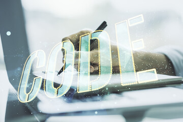 Wall Mural - creative code word hologram and hand writing in notepad on background with laptop, artificial intell