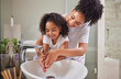 © Alexis Scholtz/peopleimages.com - Family, washing hands and child with mom rinsing, cleaning and good hygiene against bacteria or germs for infection or virus protection in bathroom. Girl kid with woman for health and cleanliness