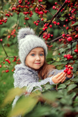 Autumn walk of a little girl with a dog in the garden