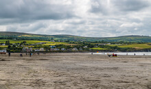 A View Along The Beach At Low Tide Towards The Town Of Newport, Pembrokeshire, Wales On A Summers Day