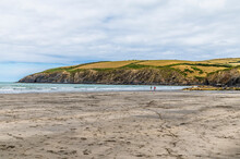A View Along The Beach At Low Tide Towards The Headland At Newport, Pembrokeshire, Wales On A Summers Day