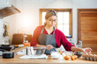 © vacancylizm - Beautiful young woman  is mixing batter, looking at camera and smiling while baking in kitchen at home ,decorating a cake of chocolate cake,cooking class, culinary, bakery, food and people concept