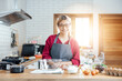 © vacancylizm - Beautiful young woman  is mixing batter, looking at camera and smiling while baking in kitchen at home ,decorating a cake of chocolate cake,cooking class, culinary, bakery, food and people concept
