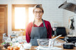 © vacancylizm - Beautiful young woman  is mixing batter, looking at camera and smiling while baking in kitchen at home ,decorating a cake of chocolate cake,cooking class, culinary, bakery, food and people concept